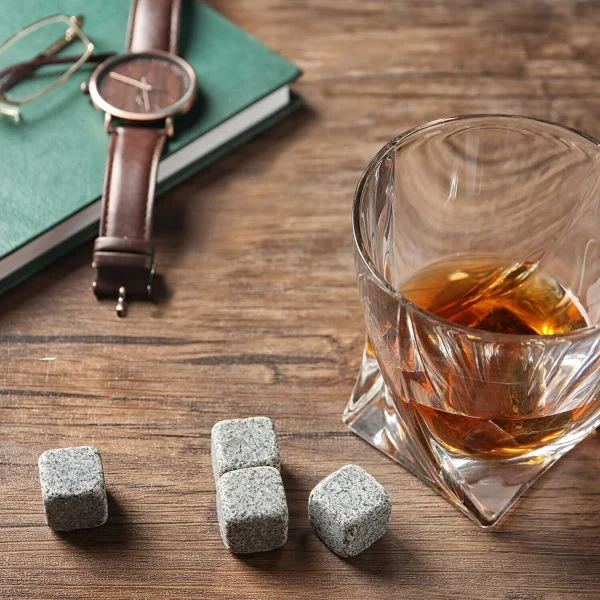 whisky stones on desk next to watch and glass